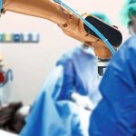 Smart_healthcare_technology_,_artificial_intelligence_concept._Selective_focus_on_automation_robot_hand_machine_in_operating_room_and_surgery_doctors_in_hospital.